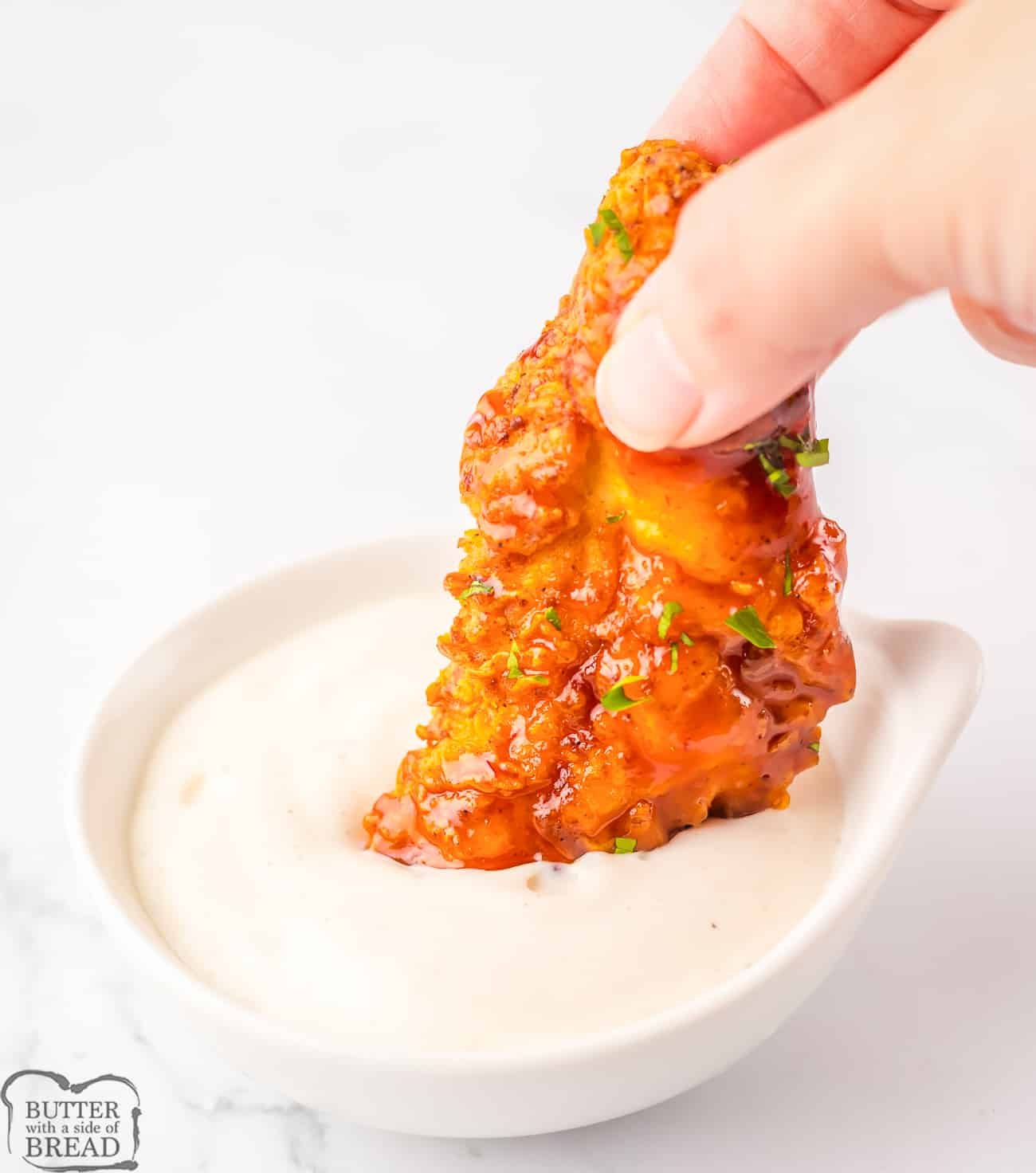 dipping a copycat Chili's chicken crisper in Ranch dip