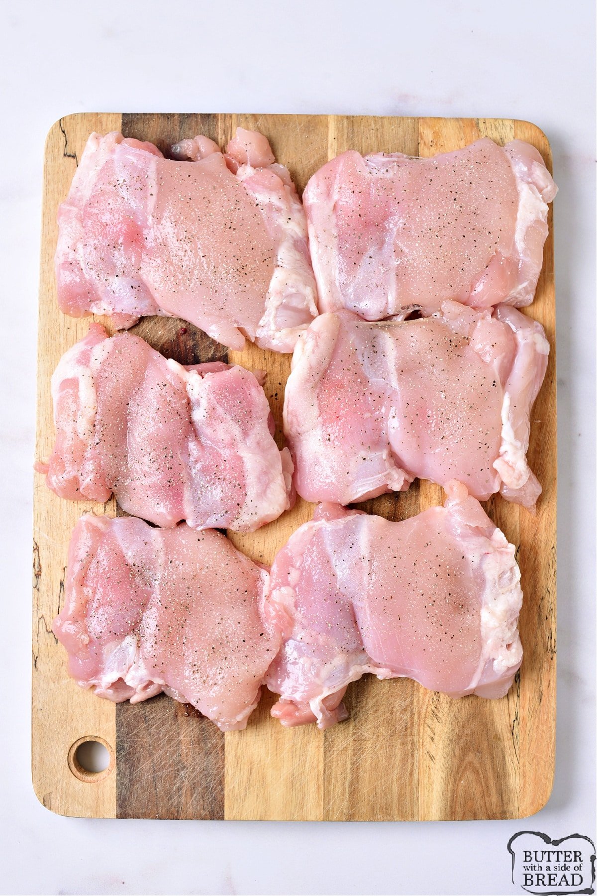 Chicken thighs seasoned with salt and pepper. 