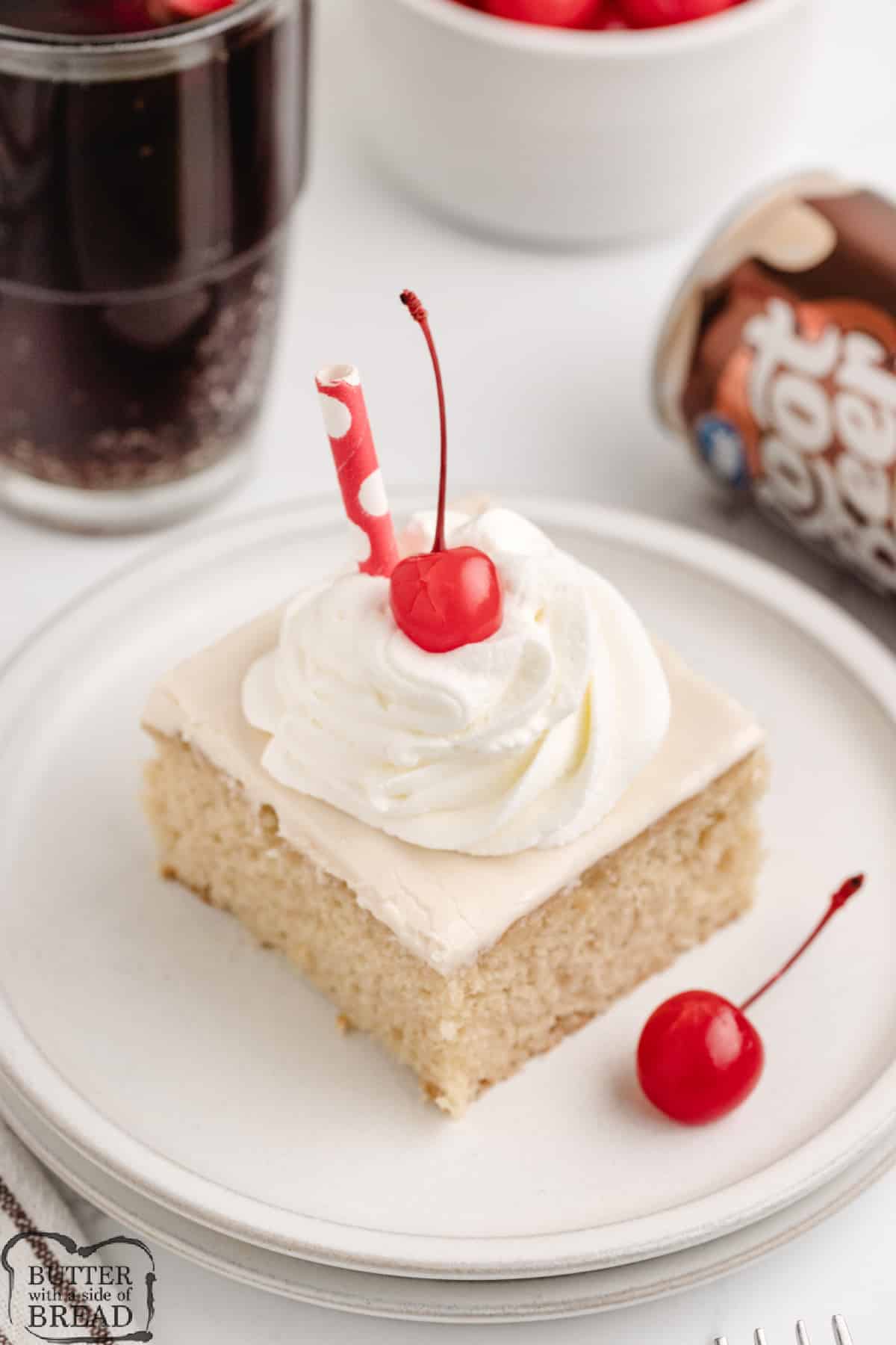 Slice of cake with whipped cream and cherries. 