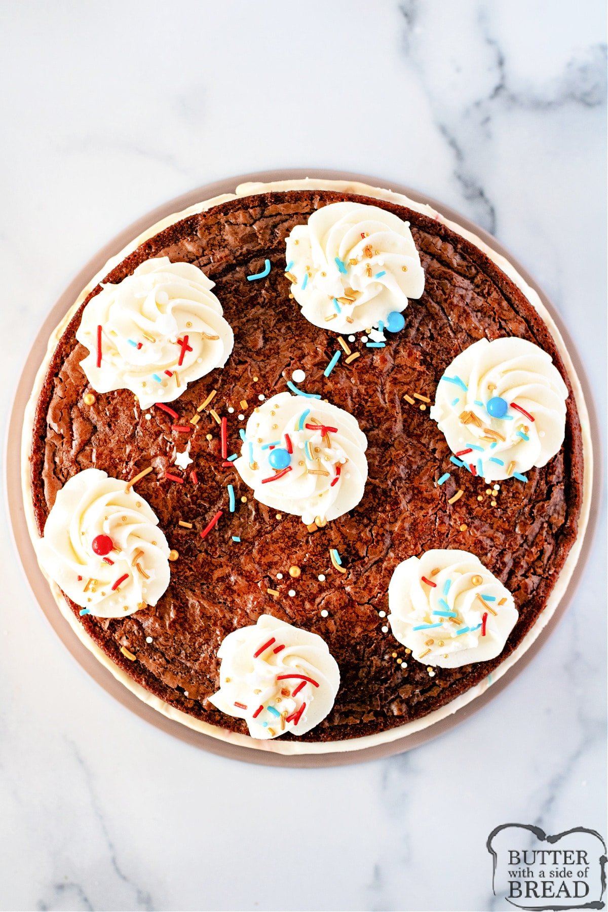 Assembled ice cream cake with whipped cream and sprinkles. 