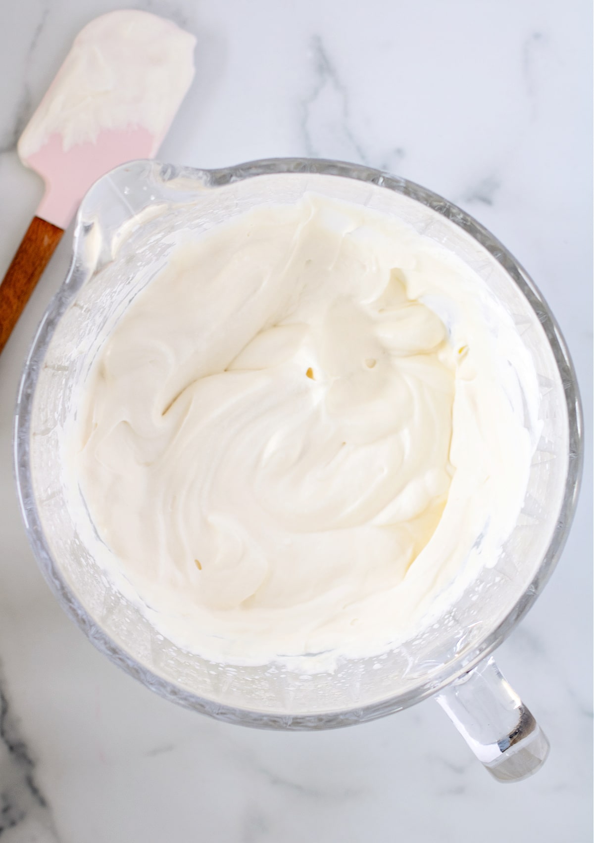 Mixing sweetened condensed milk into whipped cream. 