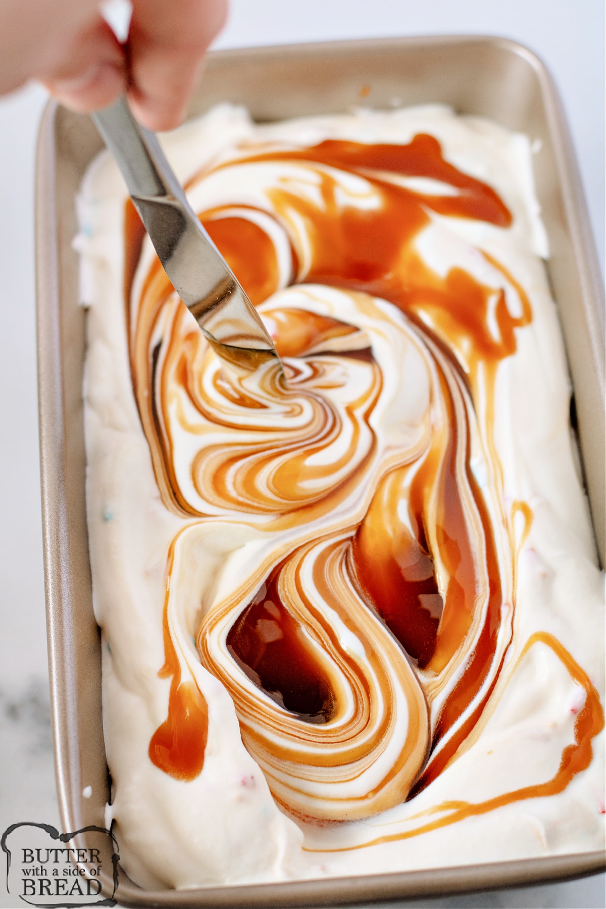 Swirling caramel into vanilla ice cream. 