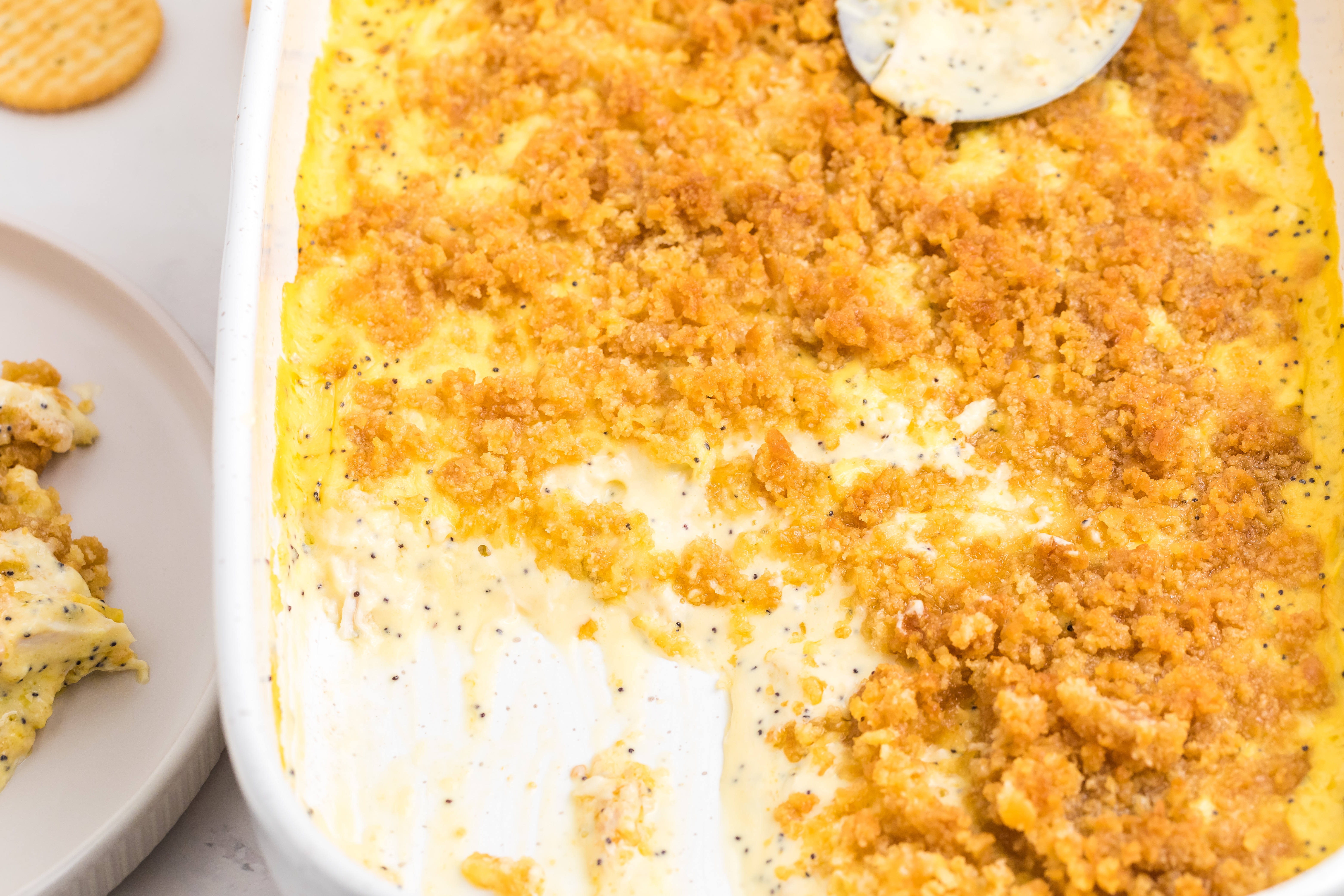 serving up chicken poppy seed casserole out of a white dish