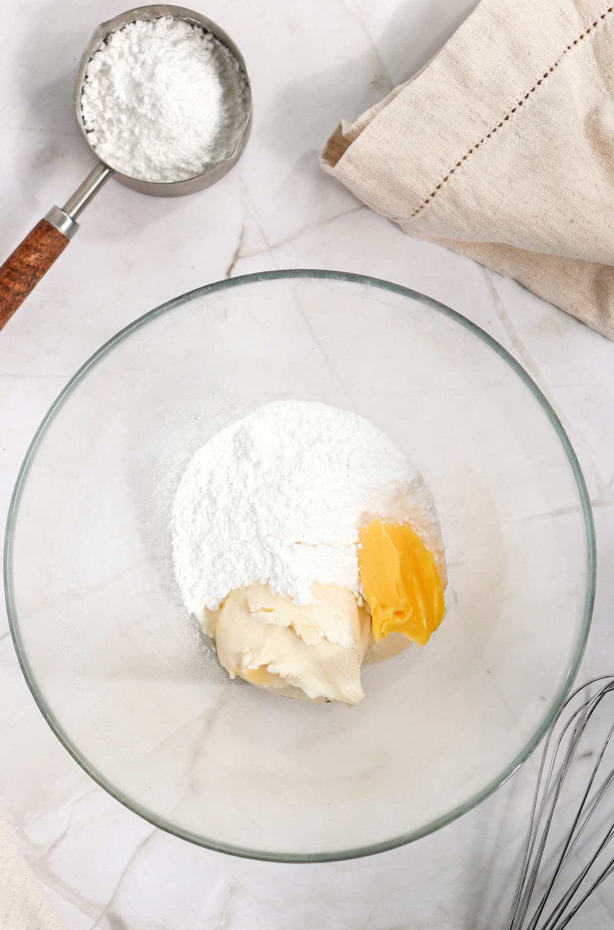 Butter, cream cheese, powdered sugar, and vanilla in a bowl. 