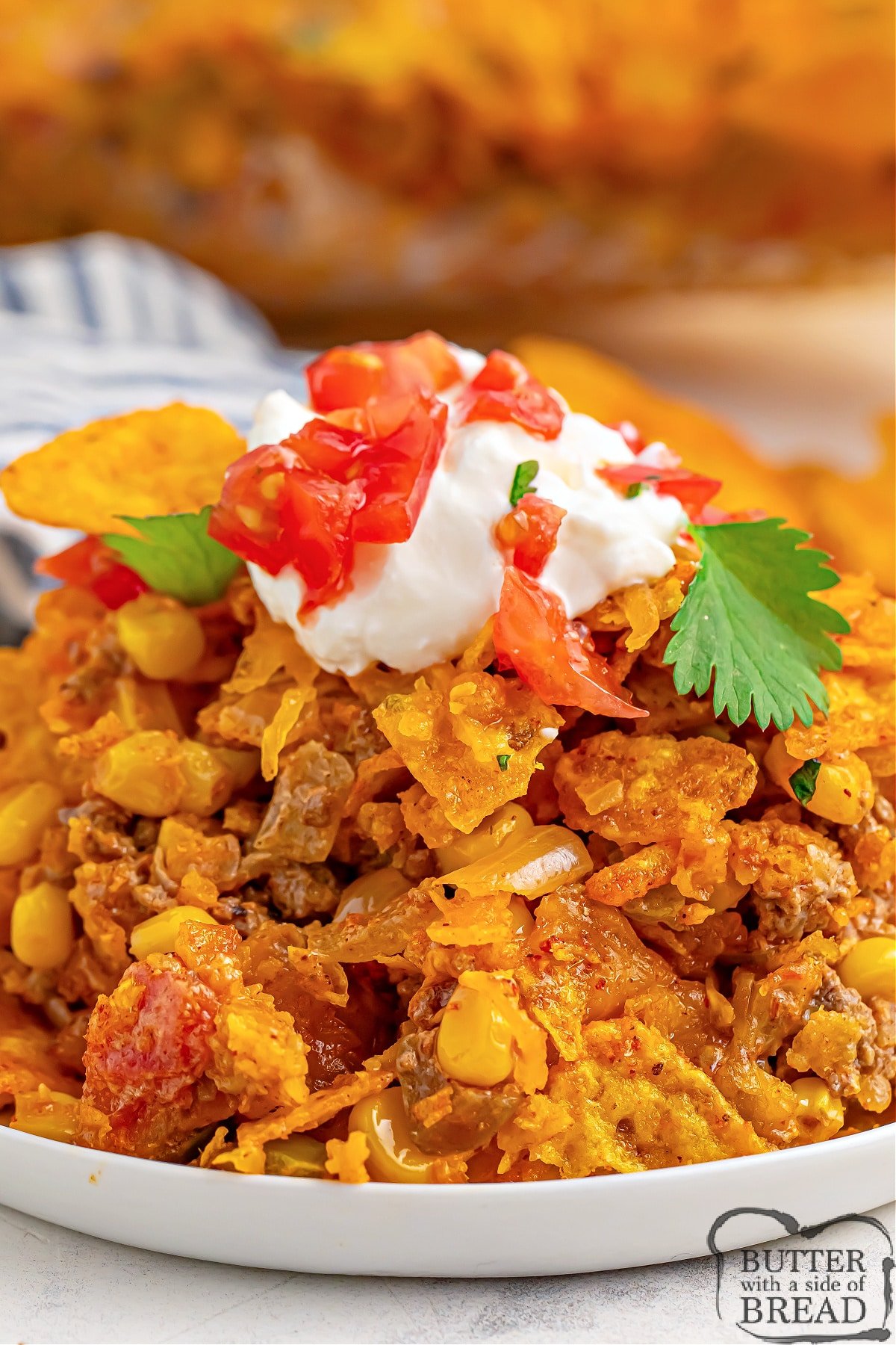 Dorito Taco Casserole made in less than 40 minutes is the perfect weeknight dinner recipe. Delicious casserole recipe made with ground beef, onion, tomatoes, corn, crushed Doritos, and cheese. 