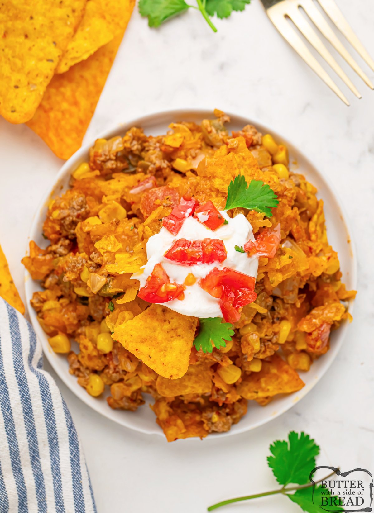 Taco casserole with sour cream and tomatoes on top. 