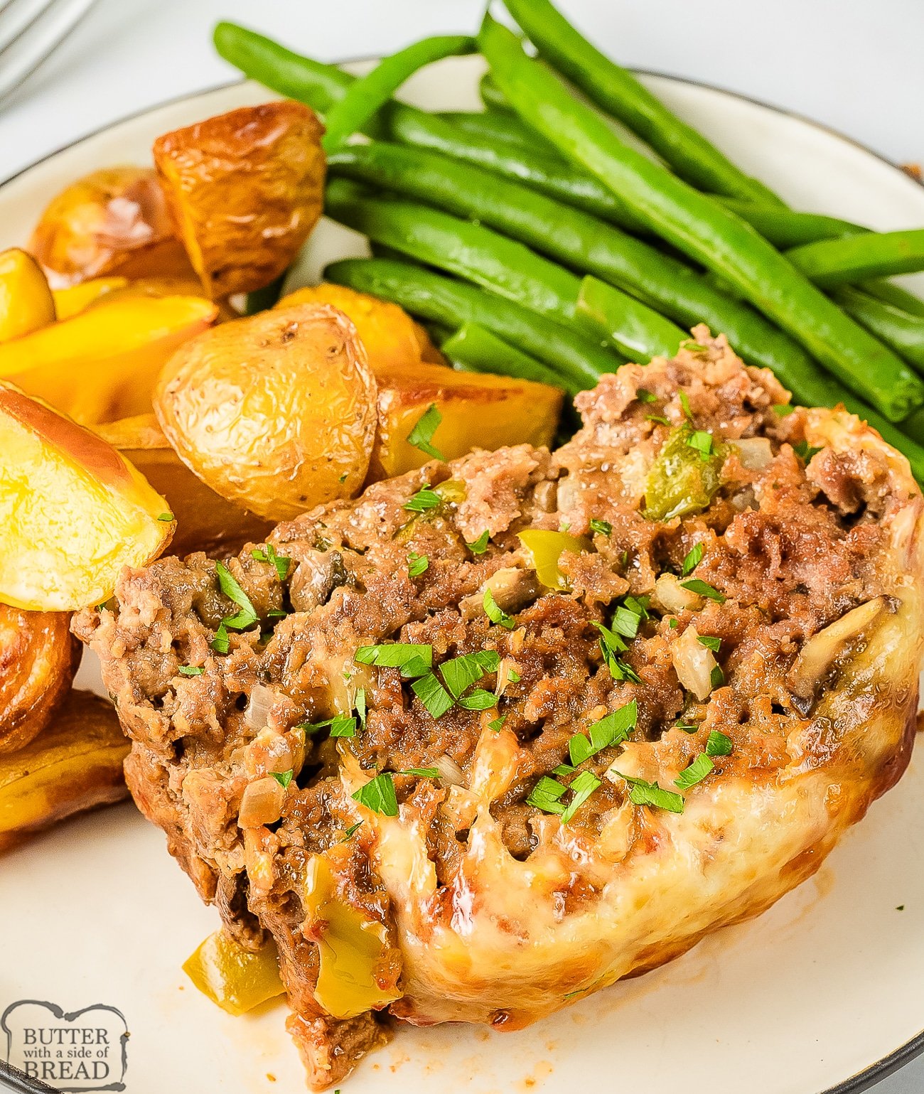 philly cheesesteak meatloaf dinner on a white plate