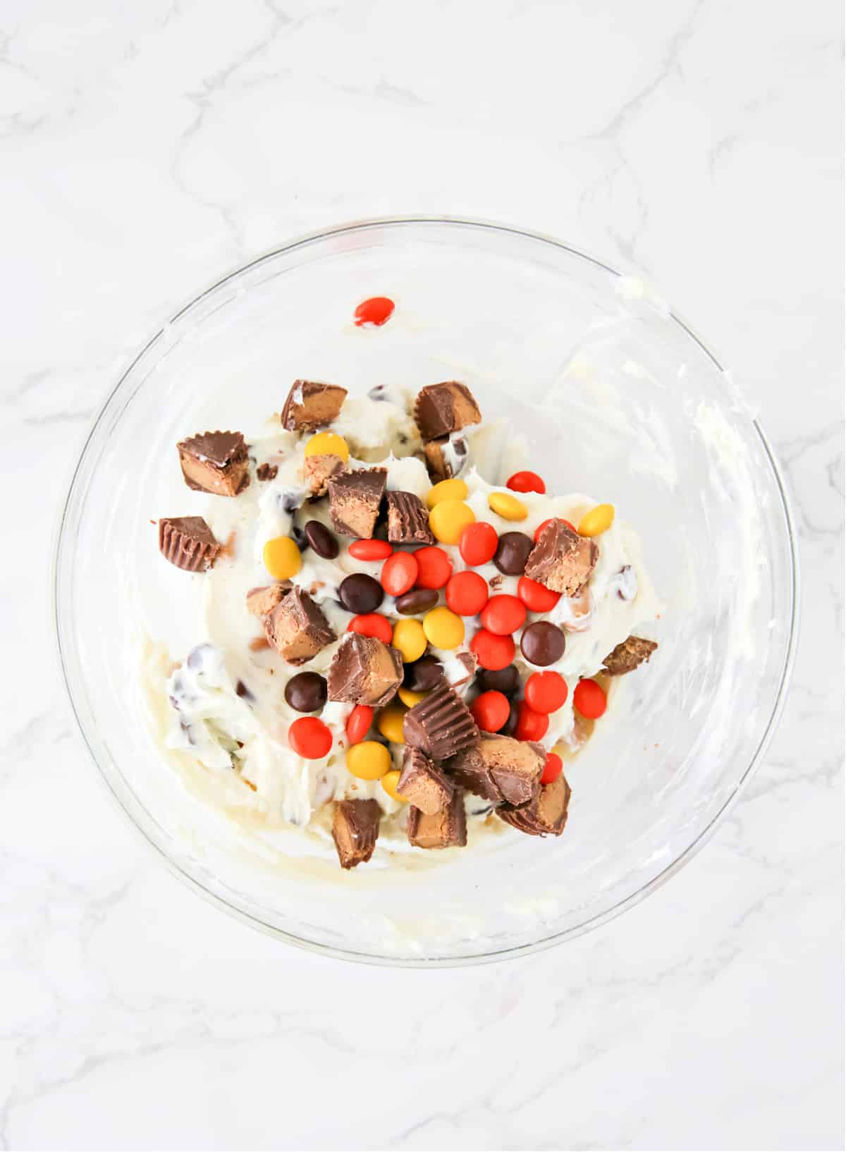 Mix Reese's pieces and chopped peanut butter cups into creamy dessert dip. 