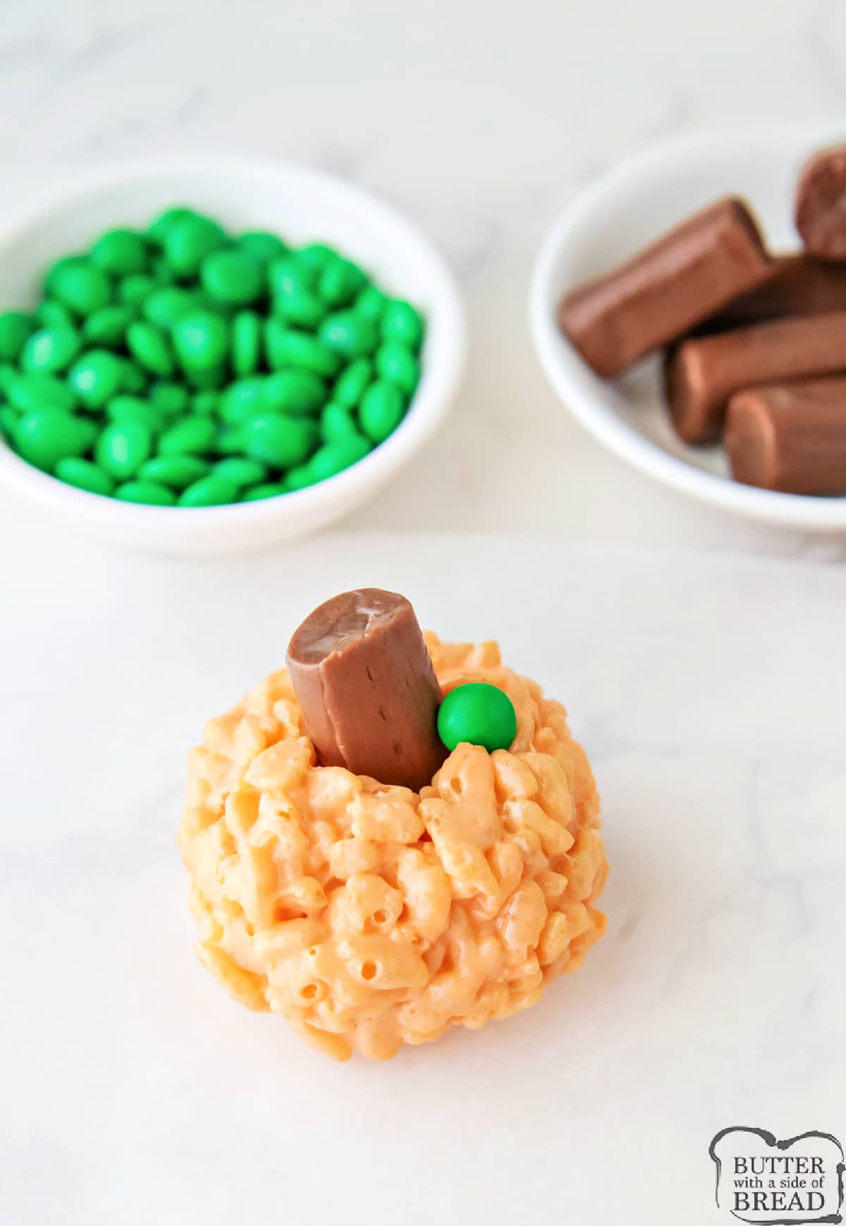 Use a tootsie roll and a miniature M&M to form the stems and leaves of the pumpkins. 