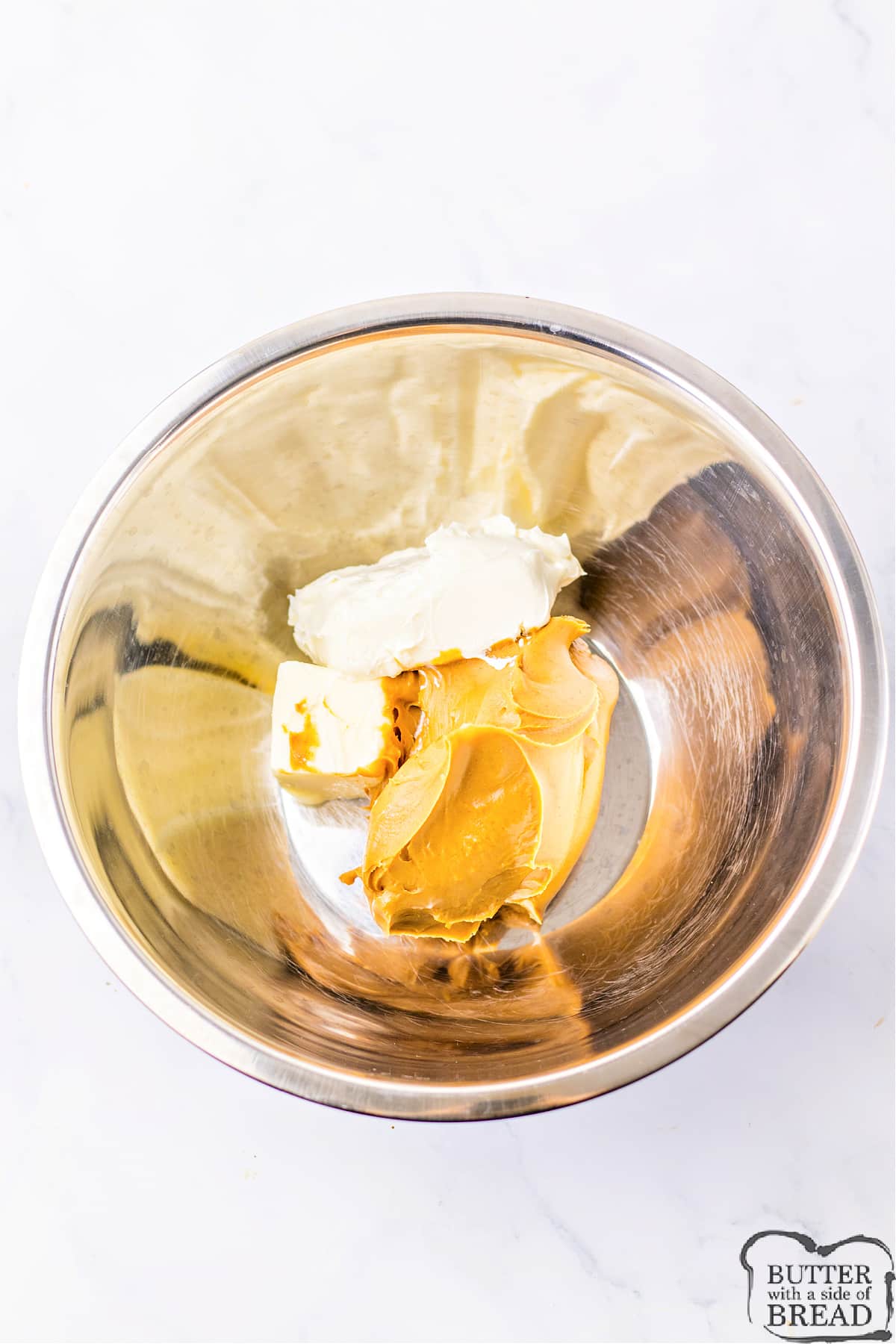 Mixing peanut butter with butter and cream cheese. 