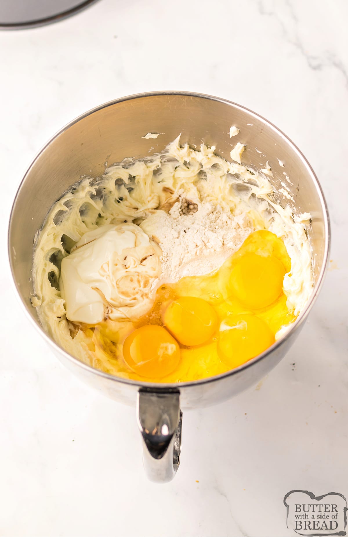 Add eggs, vanilla, flour, and sour cream to the cream cheese mixture. 