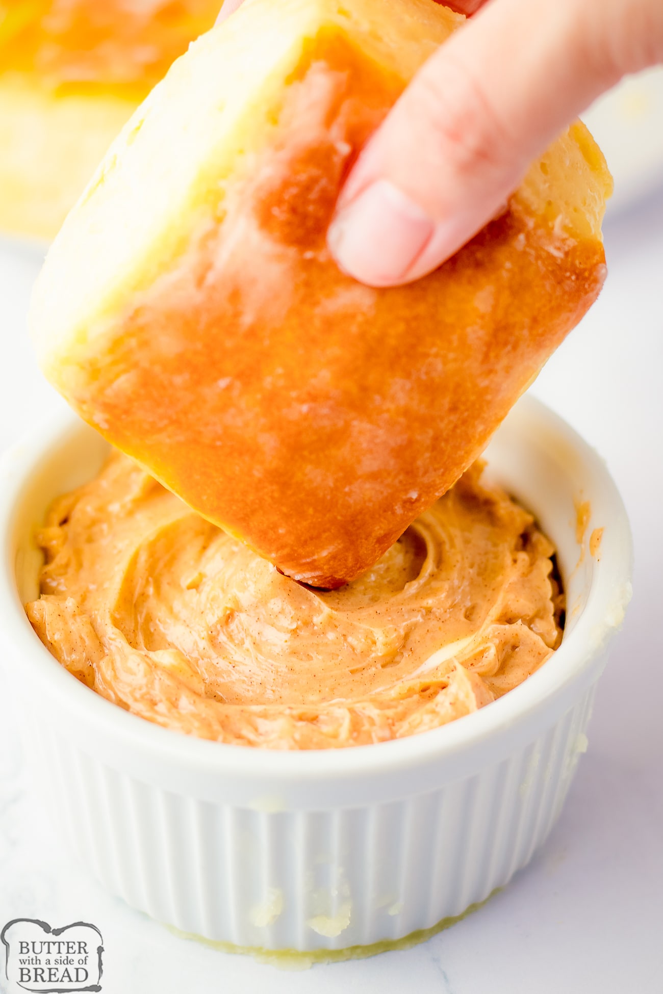 a homemade Texas Roadhouse Roll with cinnamon honey butter