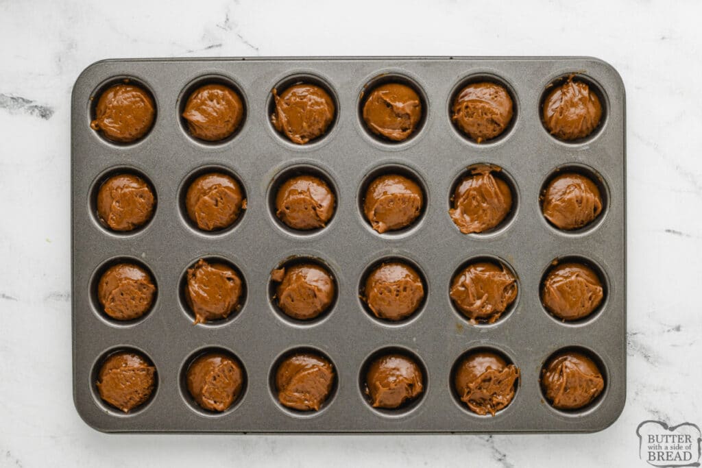 Gingerbread muffin batter scooped into mini muffin tin.