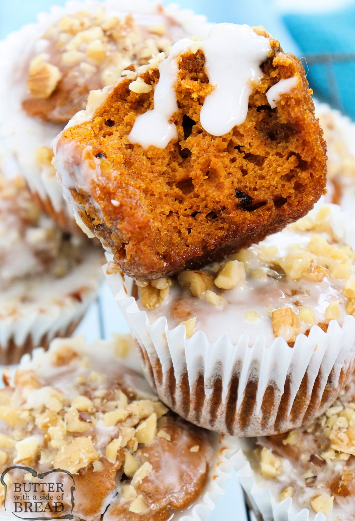 Homemade pumpkin muffins topped with powdered sugar glaze and chopped walnuts.