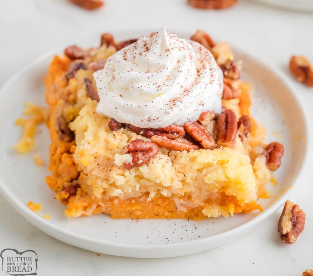 piece of pumpkin dump cake with pecans on a white plate