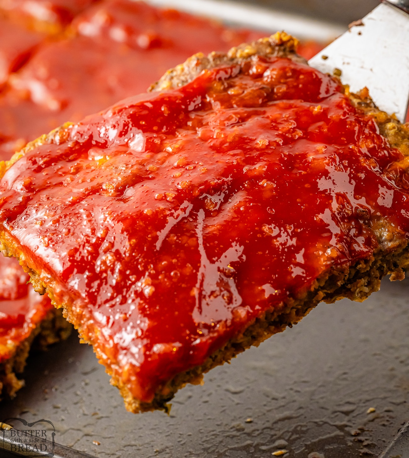 serving up a piece of sheet pan meatloaf