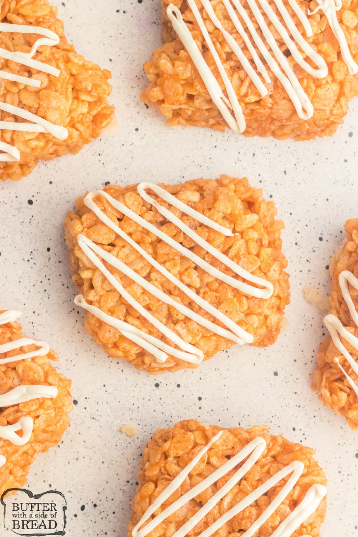 Rice Krispie treats made with pumpkin and white chocolate drizzle.