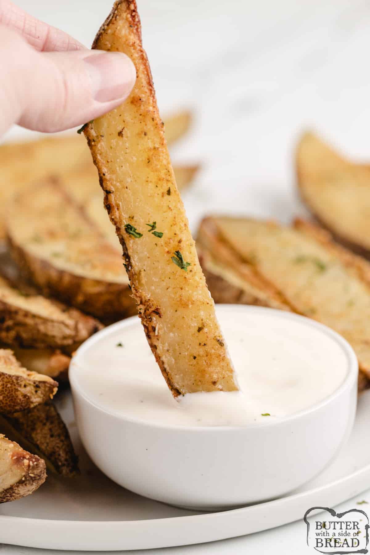Dipping a baked potato wedge in ranch dressing.
