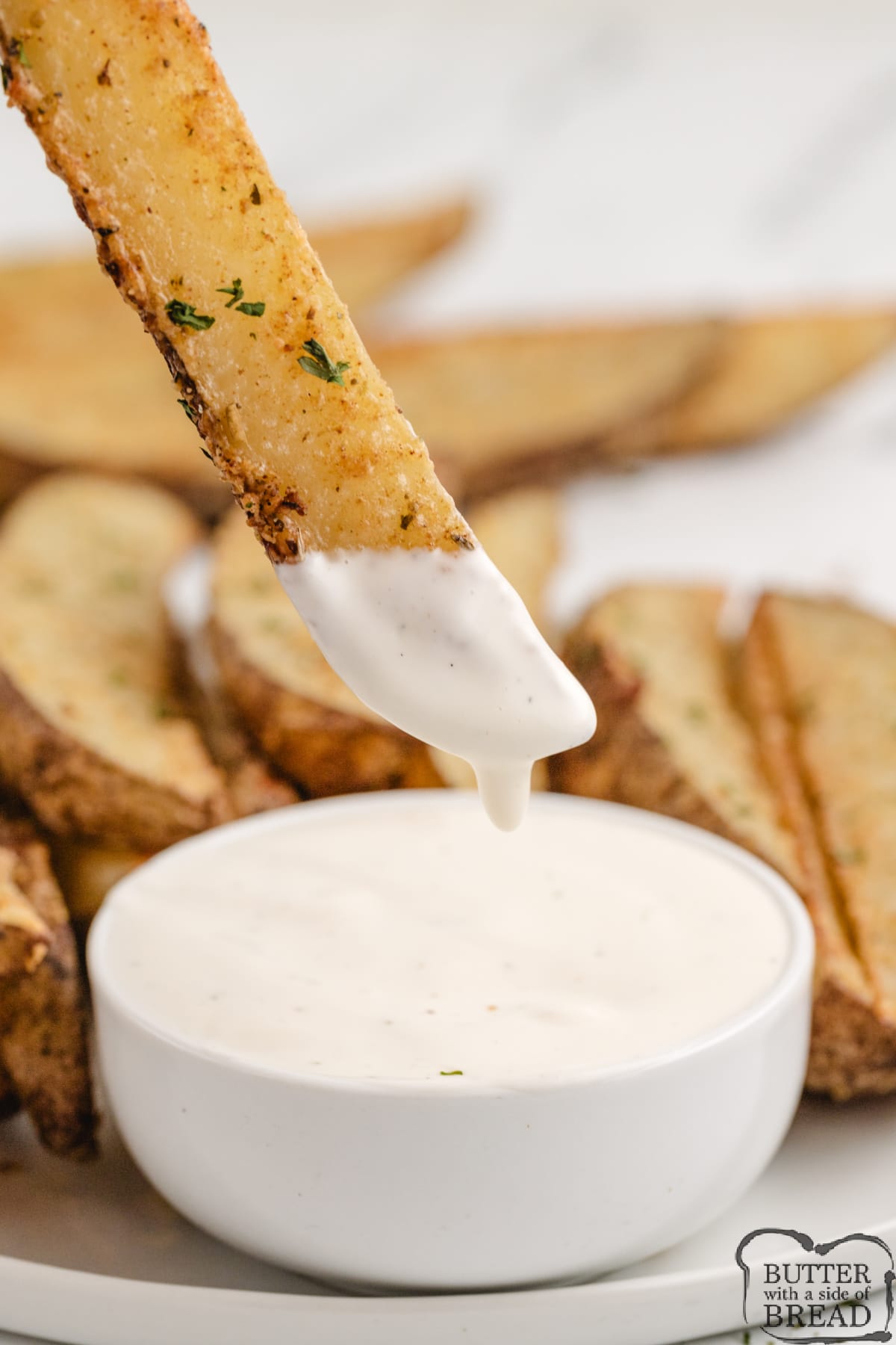 Potato wedge dipped in ranch dressing. 