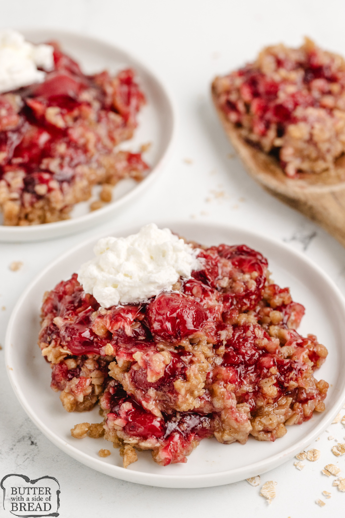 Serving of cherry crisp topped with whipped cream.
