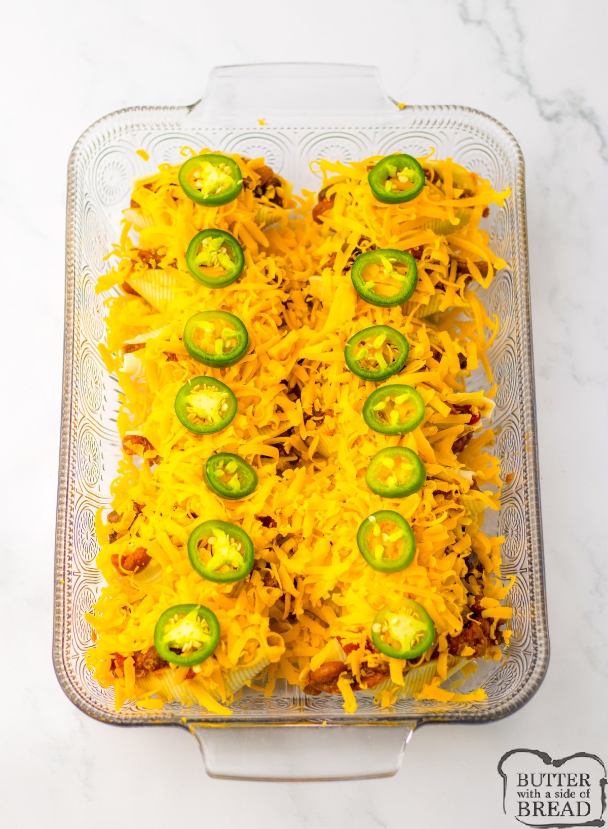 Top stuffed shells with cheddar and sliced jalapenos.