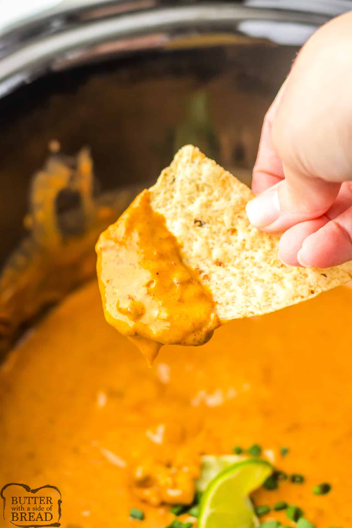 Copycat Chili's Queso Dip is so easy to make in the slow cooker! This simple chip dip is made with Velveeta cheese, canned chili, a few simple spices, and a splash of lime.