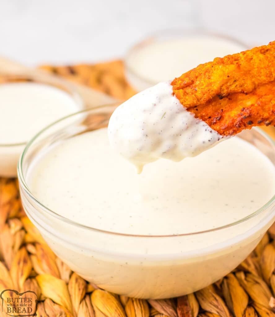 wingstop Ranch in a bowl with a chicken wing dipped in it