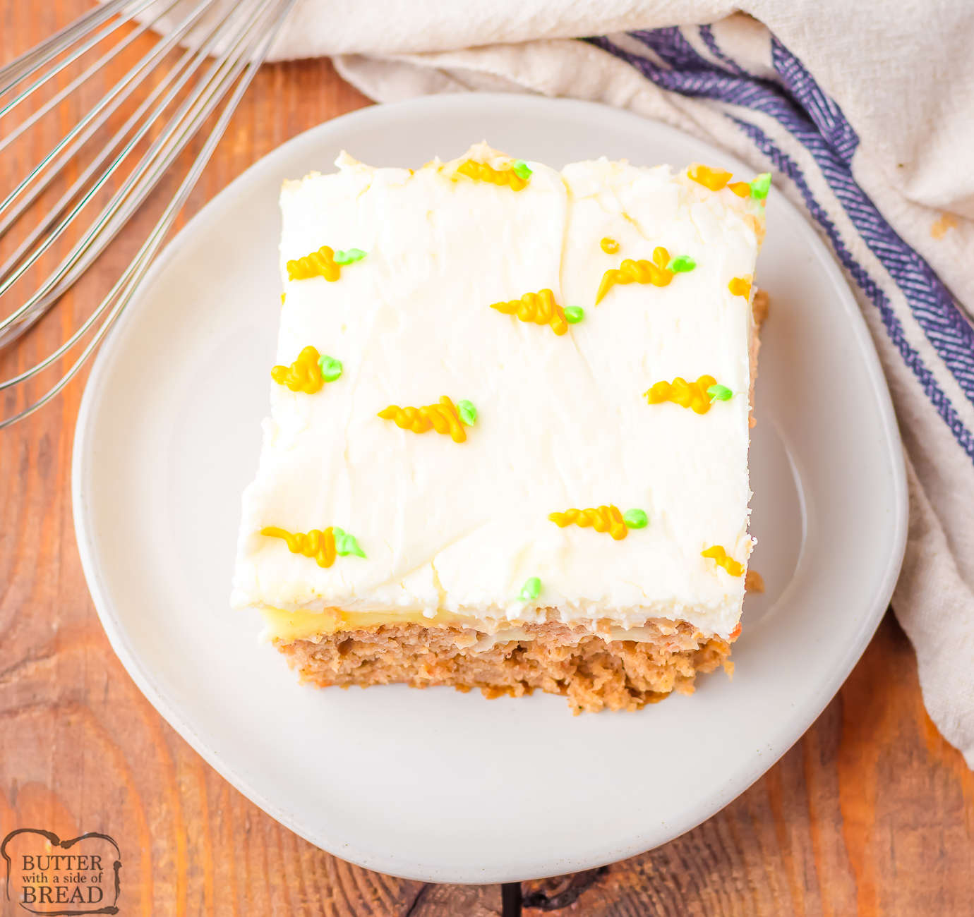 slice pf carrot cake poke cake with tiny frosting carrots on top