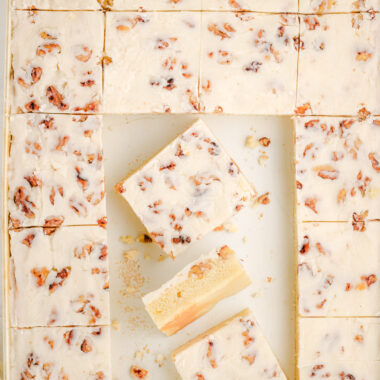 white sheet cake in a baking pan with slices cut out