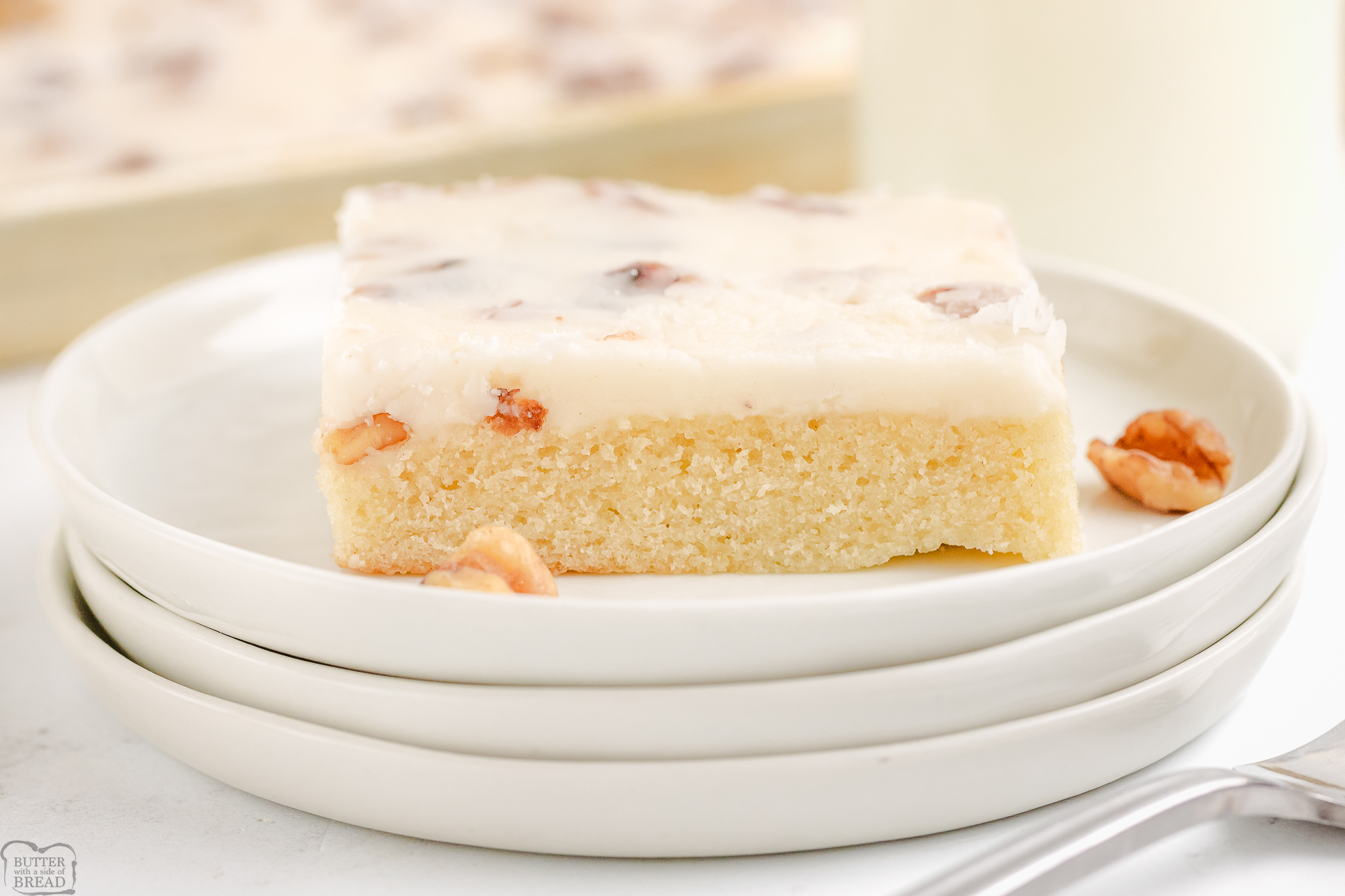 slice of White sheet cake topped with walnuts