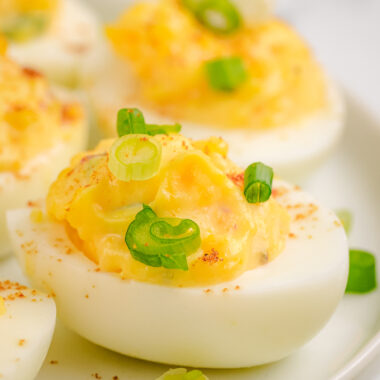 chipotle deviled eggs topped with green onions and smoked paprika