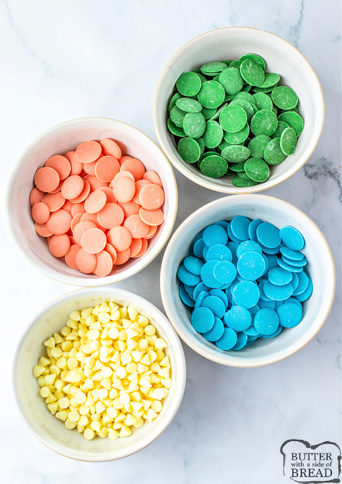 White chocolate chips, blue candy melts, pink candy melts, and green candy melts.