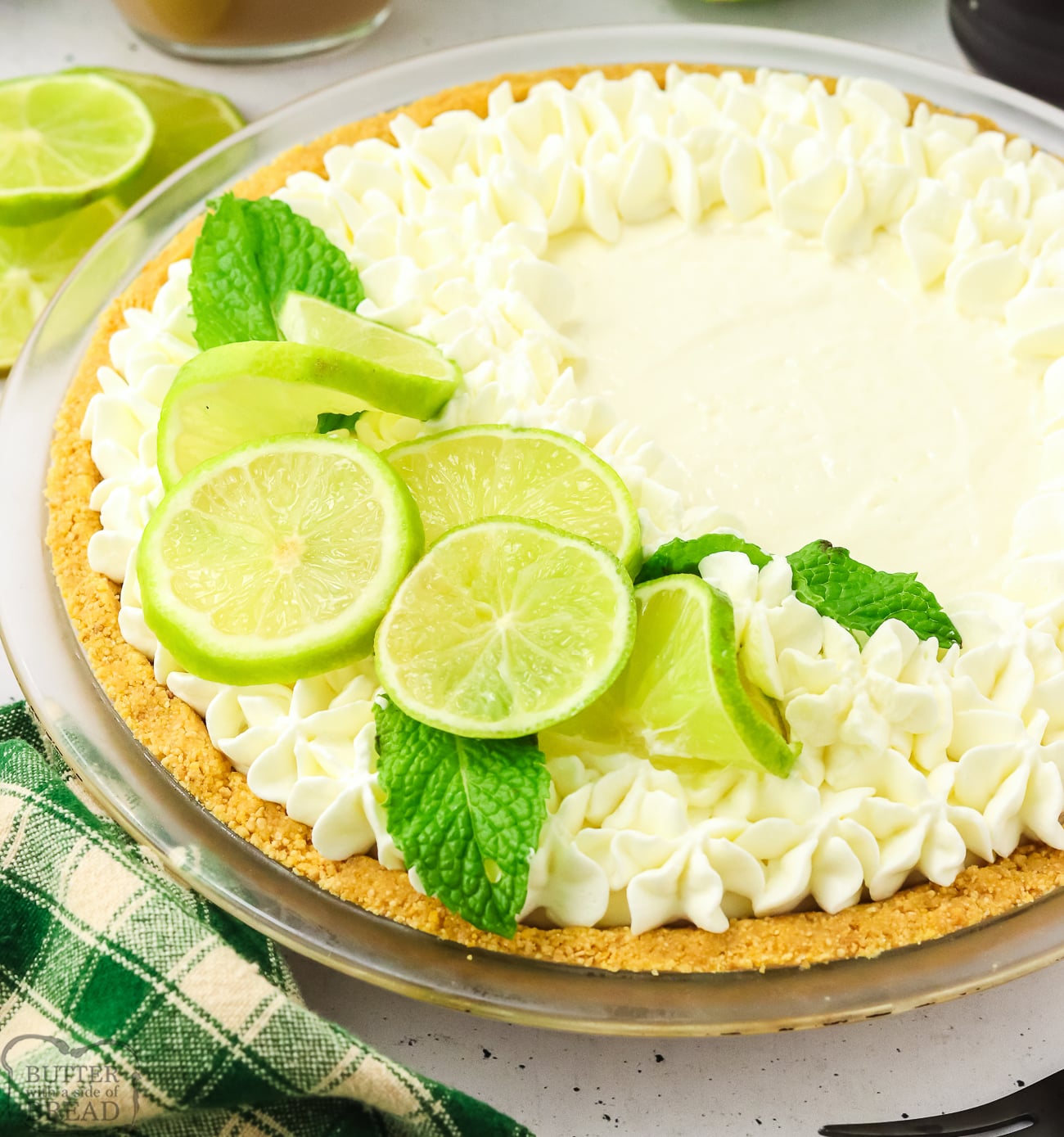 whole key lime pie topped with whipped cream and lime slices