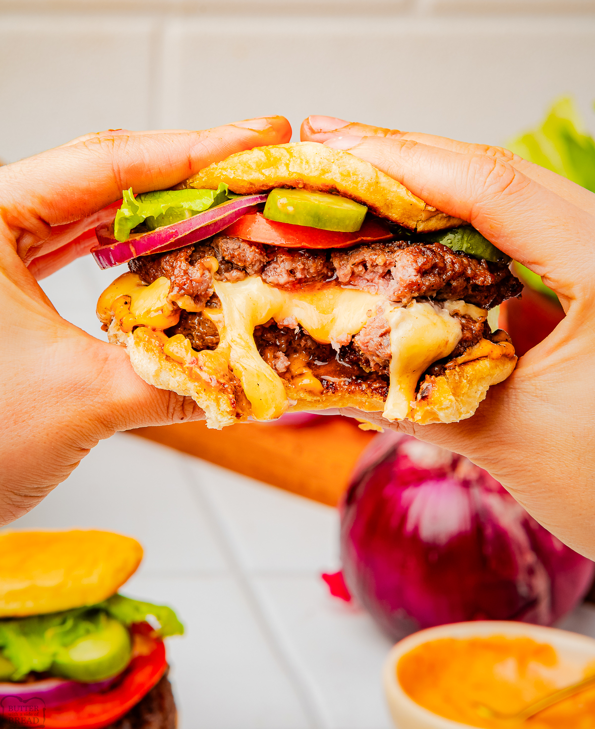 holding a Juicy Lucy burger with a bite taken out