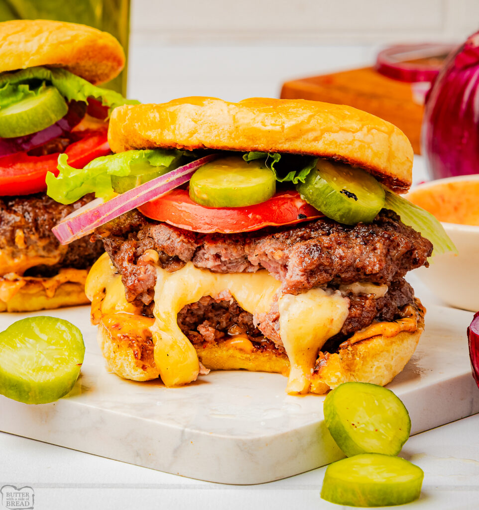 homemade Juicy Lucy cheese stuffed burger with a bite taken out and cheese oozing from the beef
