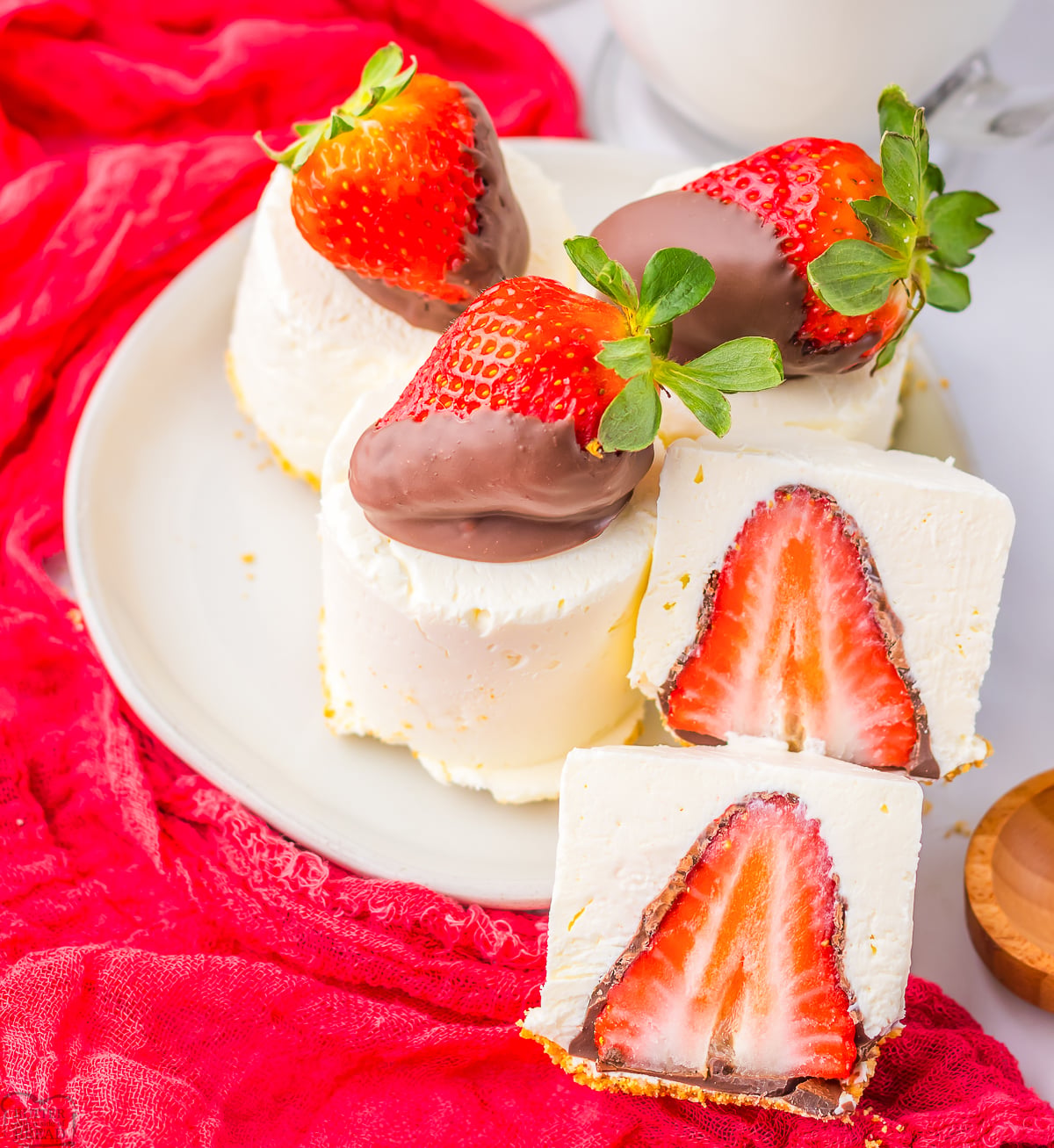 chocolate covered strawberry cheesecakes on a white plate