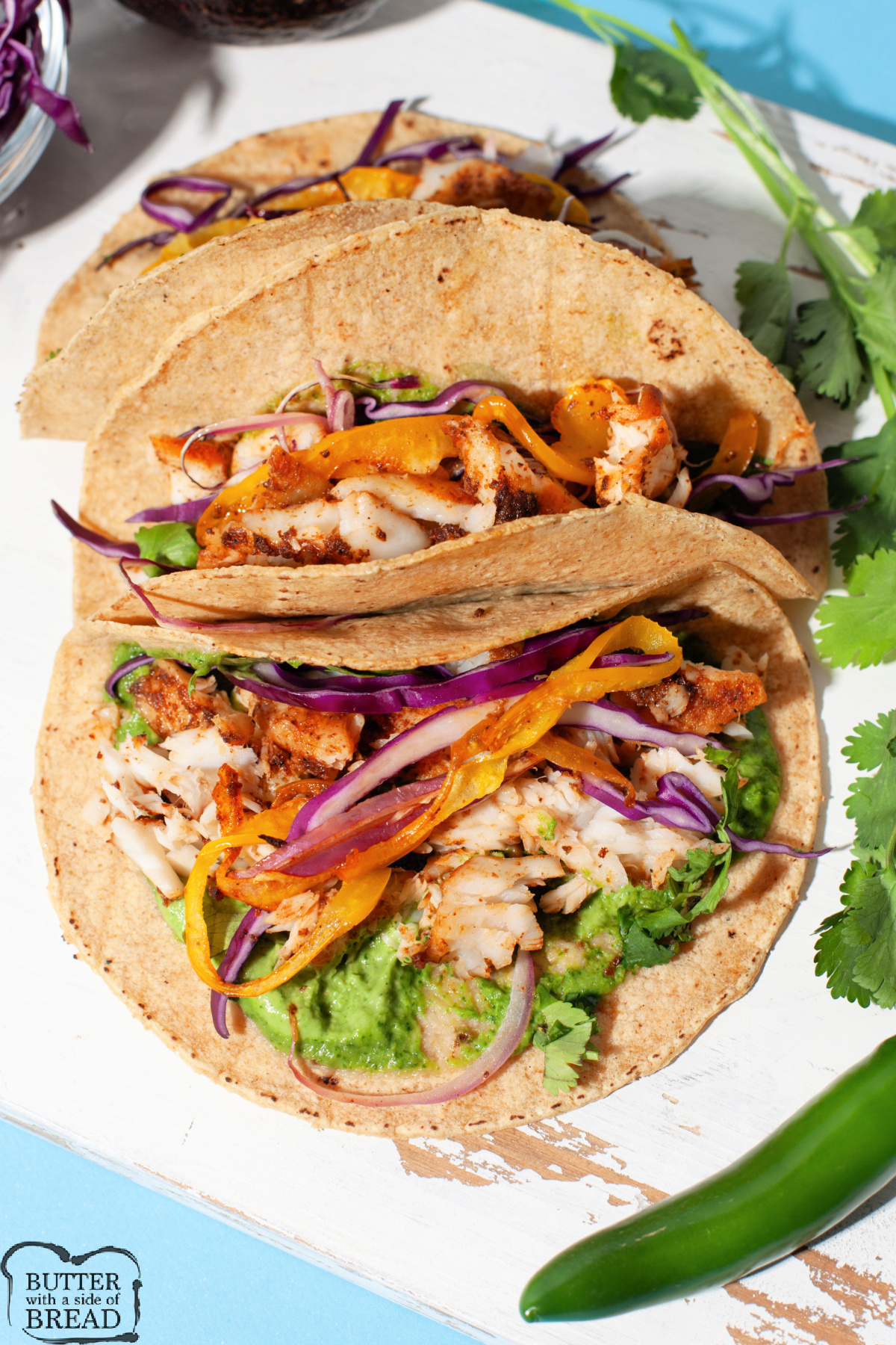 Fish tacos made with tilapia, red onions, bell peppers, and an avocado cream sauce.