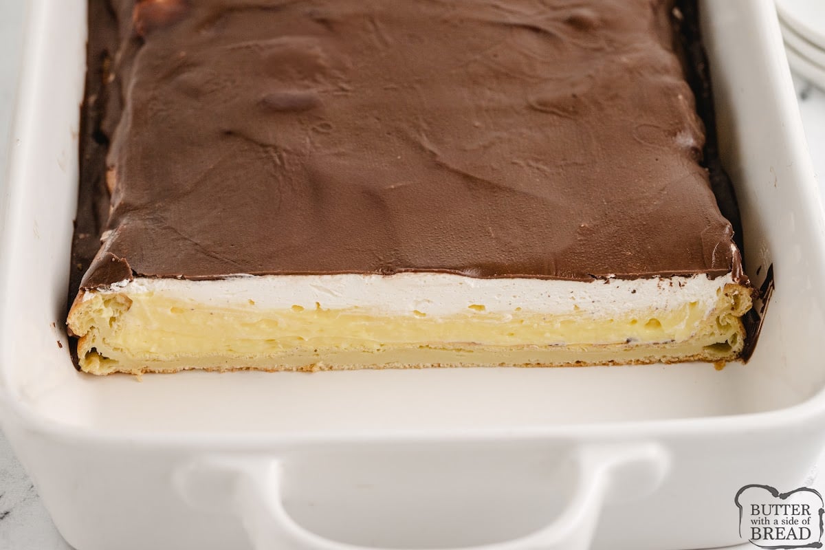 Layered dessert made with vanilla pudding, pastry layer, Cool Whip, and chocolate. 