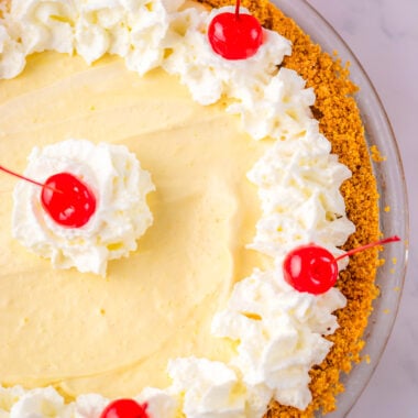 dr pepper cream pie with cherries and cream on top