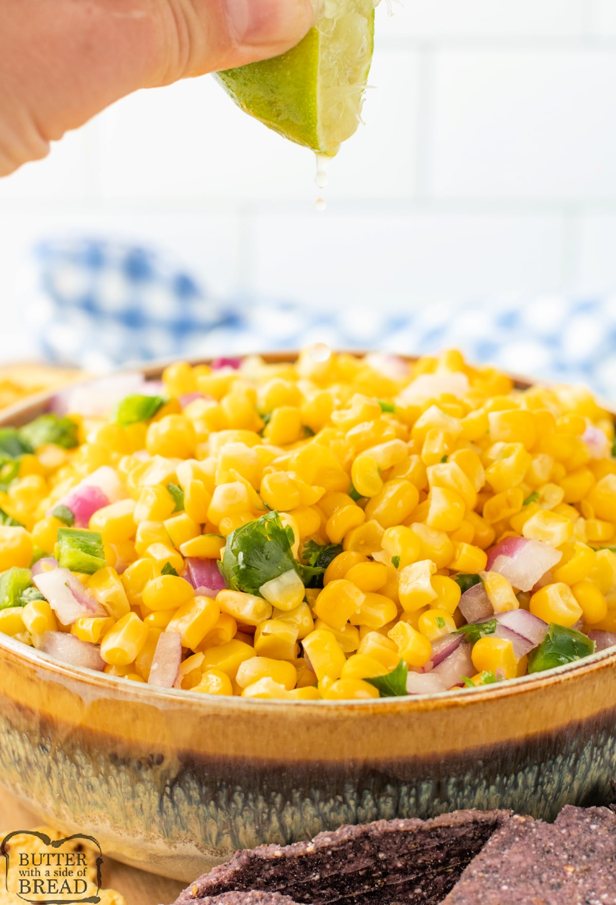 Squeezing fresh lime juice into corn salsa recipe.