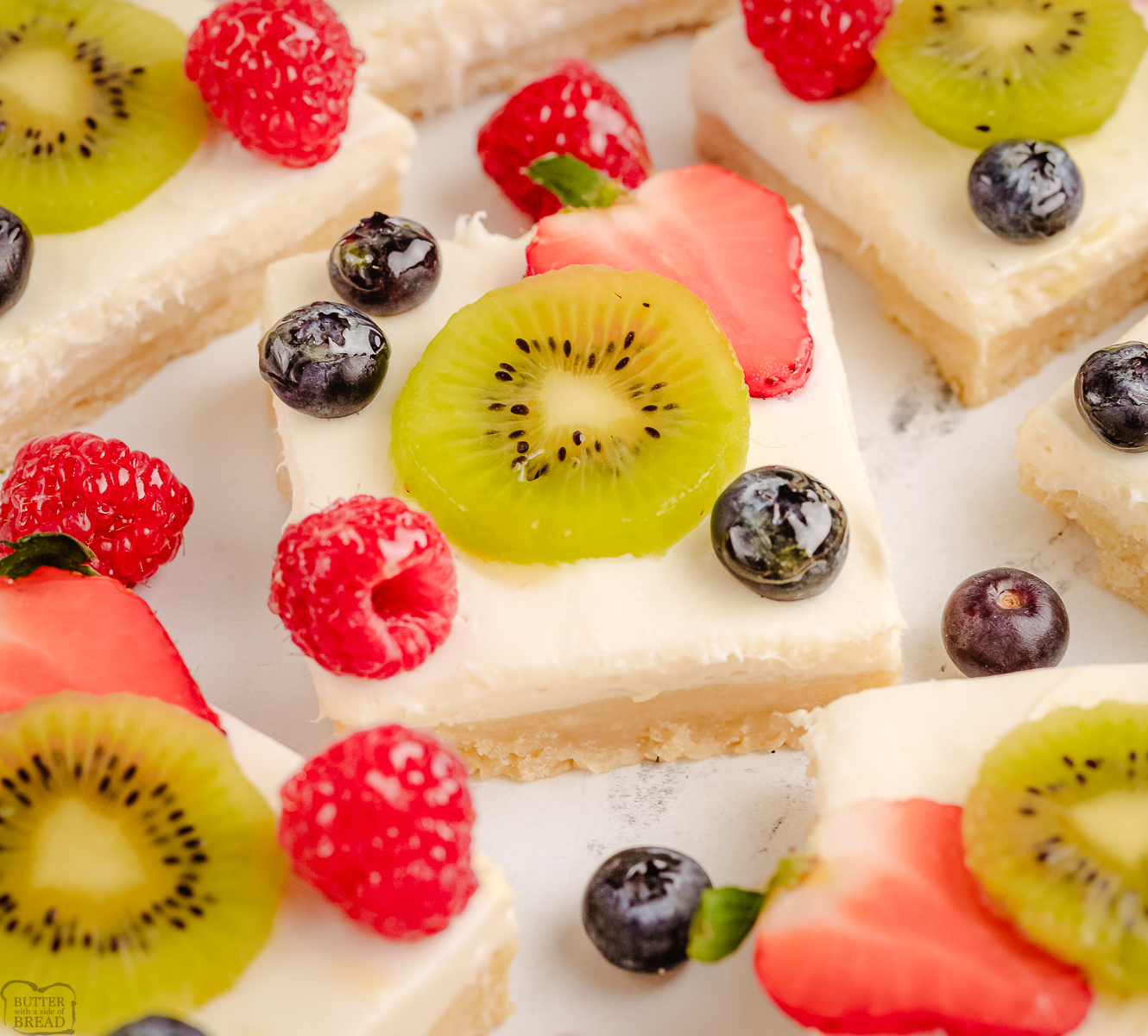 fresh kiwi fruit and berries placed on top of buttery cheesecake bars