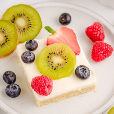cheesecake bars topped with sliced kiwi fruit and berries