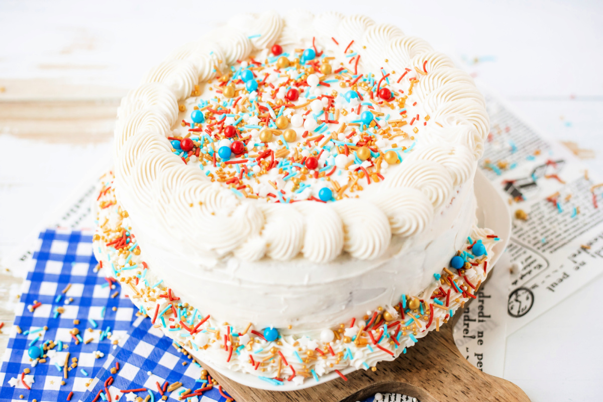 Patriotic Poke Cake is a red, white & blue layered cake filled with Jello and topped with creamy frosting&mdash;perfect for July 4th!