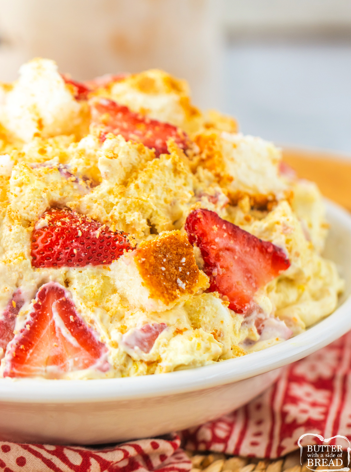 Bowl of Strawberry Shortcake Fluff topped with crushed graham crackers and fresh strawberry slices.