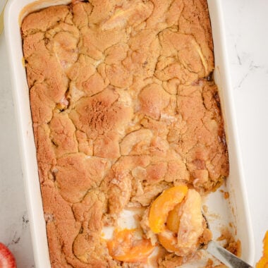 Apple and Peach Cobbler in a baking dish with a scoop taken out