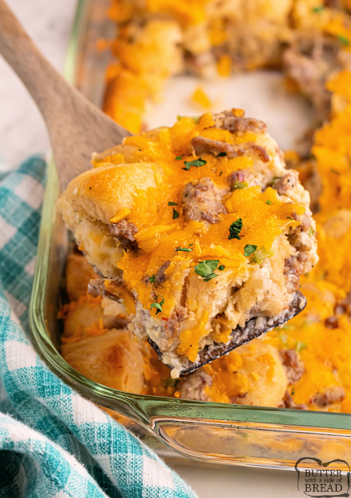 Close-up of Biscuits and Gravy Casserole showing layers of biscuits, savory sausage, creamy gravy, and melted cheese.