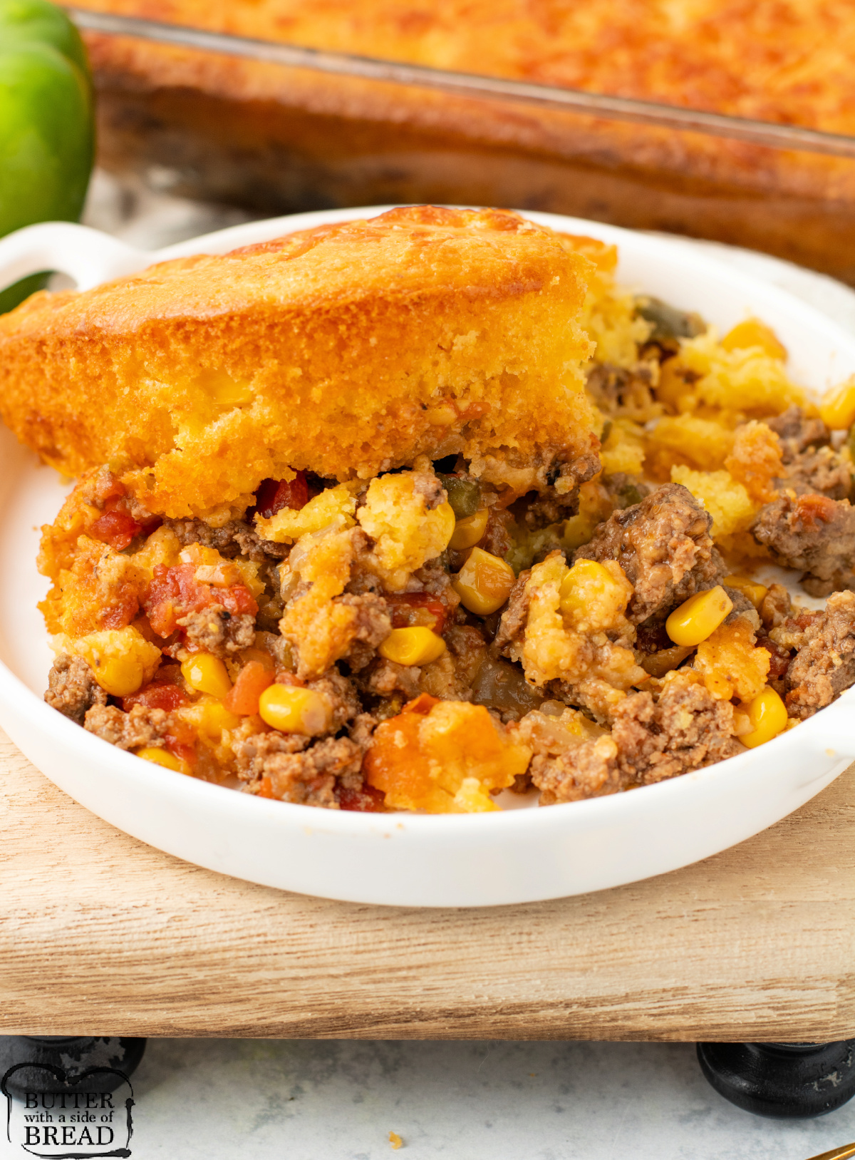 Serving of ground beef casserole with cornbread on top.