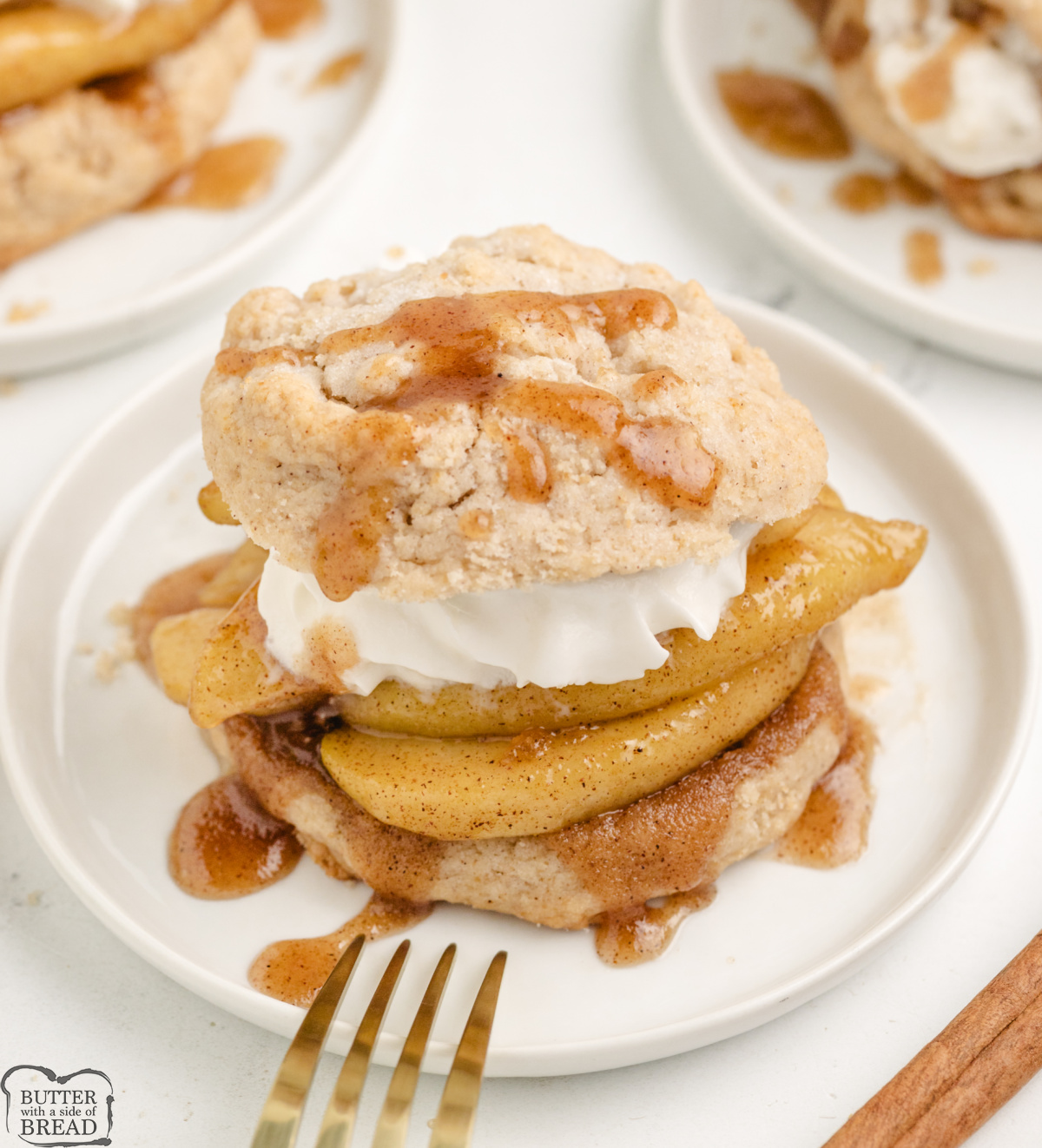 Close-up of shortcake topped with warm cinnamon apples and whipped cream.