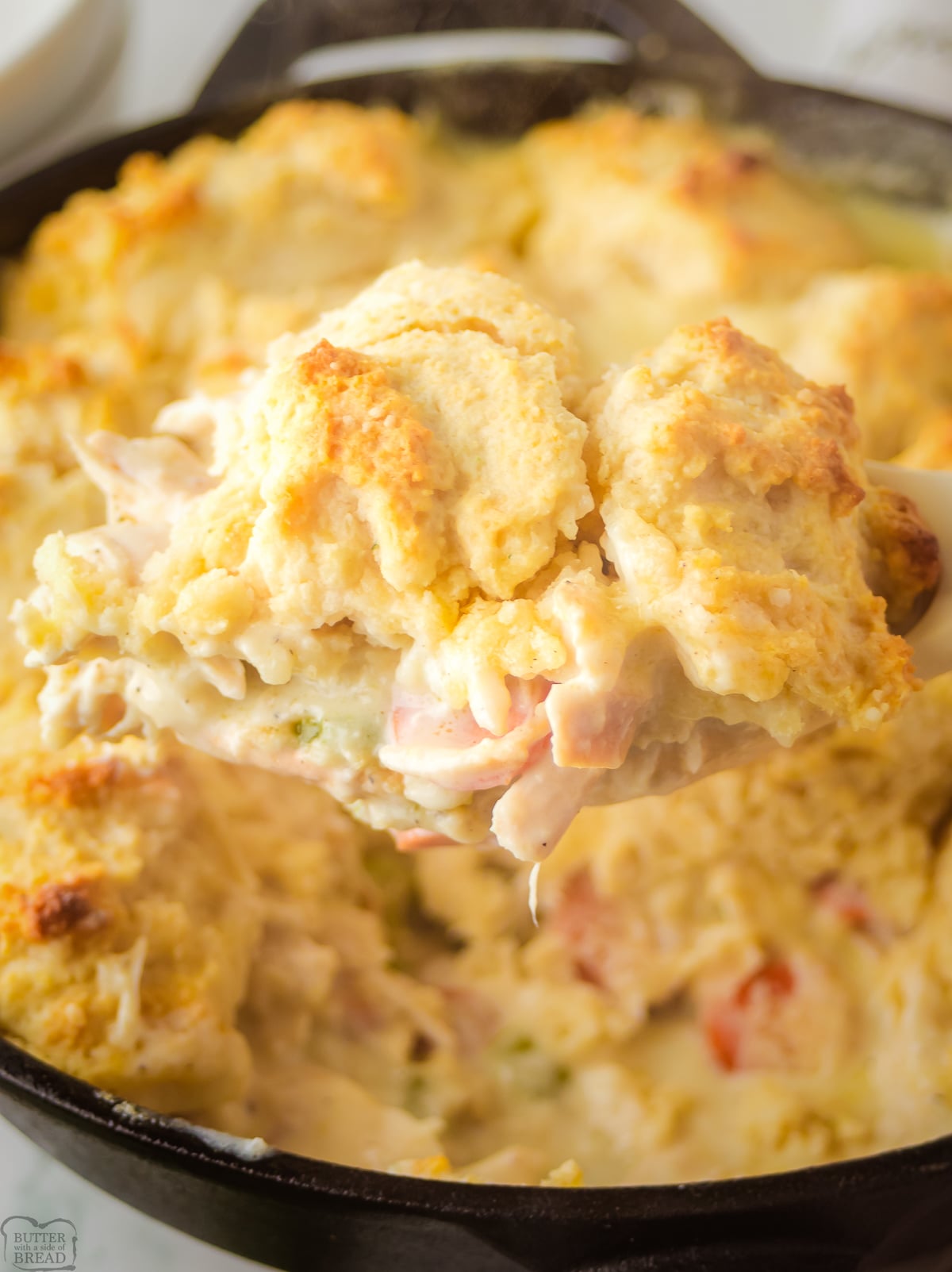 cheddar bay biscuit chicken pot pie with a scoop taken out of a skillet