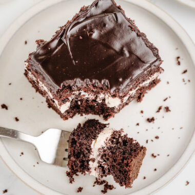 taking a bite of a chocolate cream cake